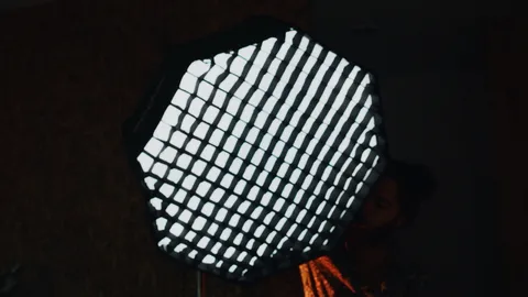 A softbox glowing in a dark studio, behind the scenes at UMMONTE